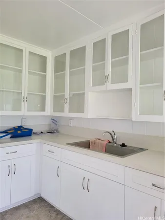 a kitchen with stainless steel appliances granite countertop white cabinets and a sink