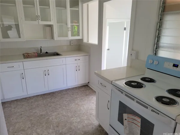 a kitchen with sink stove and cabinets