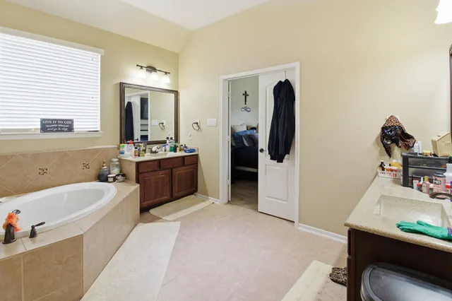 a bathroom with a tub sink and mirror