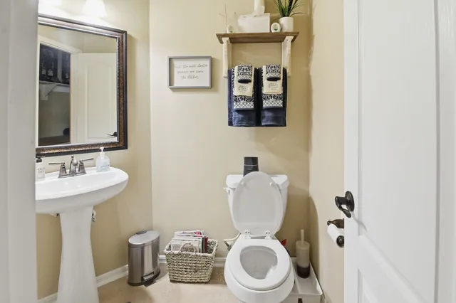 a bathroom with a toilet sink and mirror