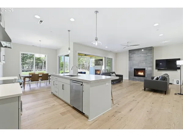 a large white kitchen with furniture a large window and a fireplace