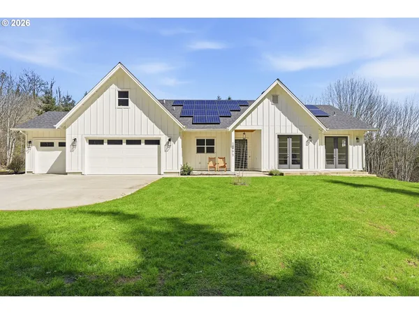 a view of a house with a big yard potted plants and large tree