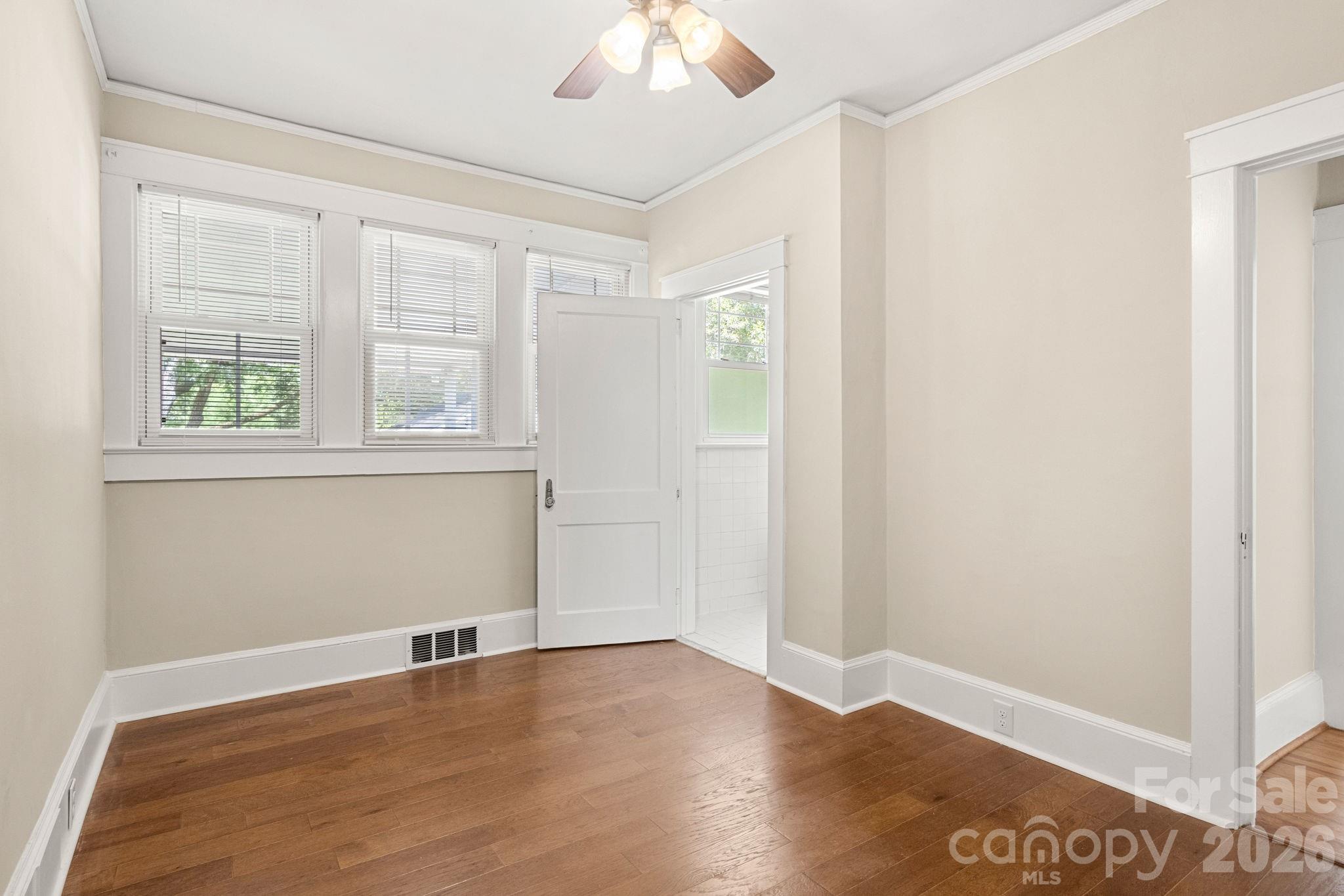 108 Reedy Street Chester, SC 29706 - Photo 17 of 42 an empty room with wooden floor chandelier fan and windows