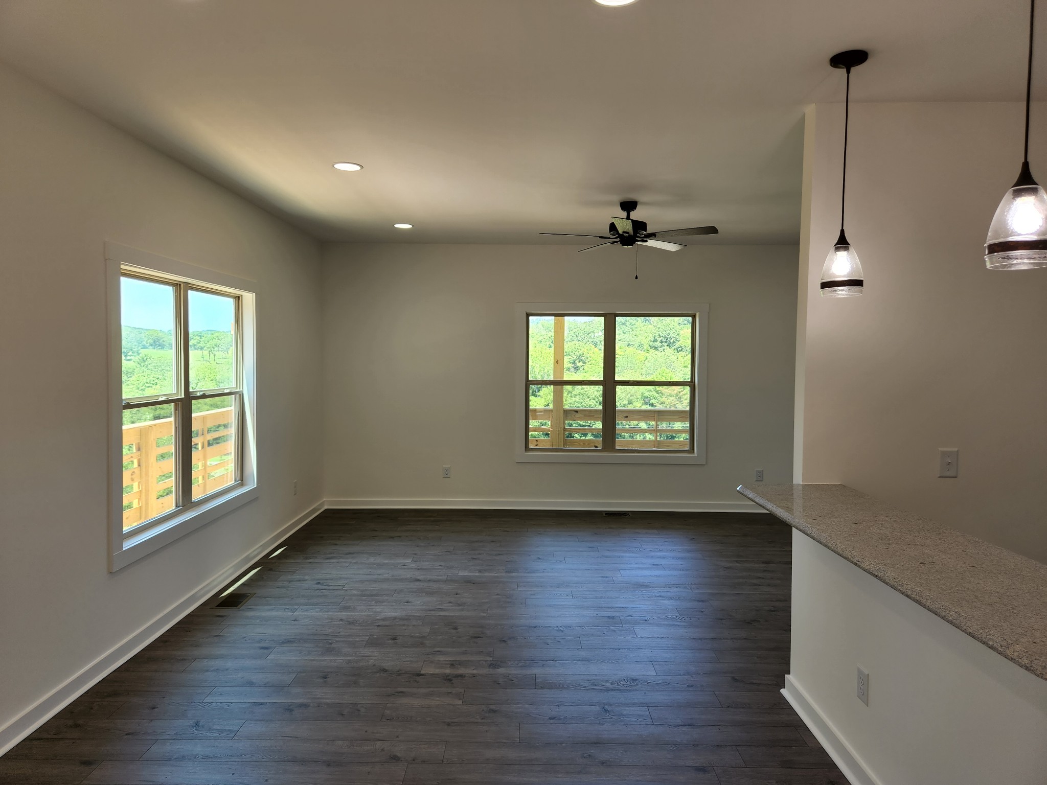 62 Shoulders Road Dixon Springs, TN 37057 - Photo 3 of 22 an empty room with wooden floor a ceiling fan and windows