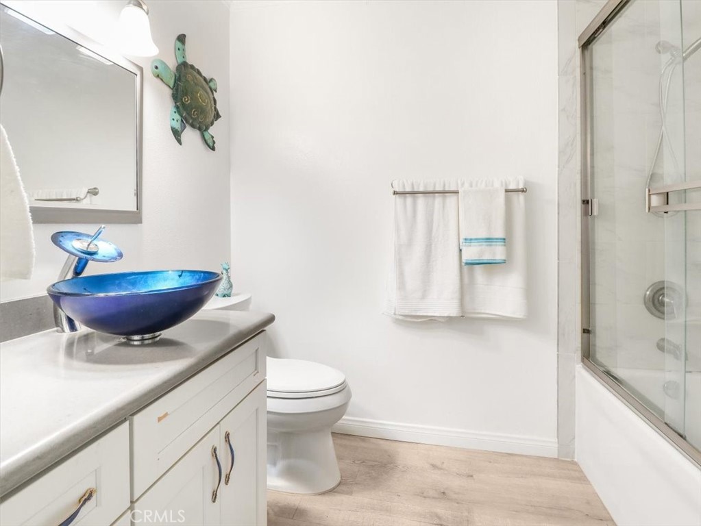 628 Daisy Avenue, Unit 222 Long Beach, CA 90802 - Photo 15 of 20 a bathroom with a granite countertop sink a toilet and a mirror