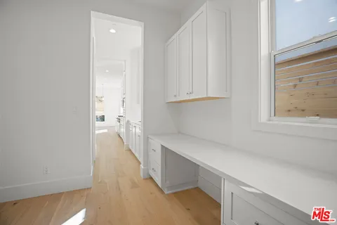a view of a kitchen with white cabinets
