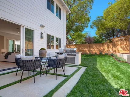 a view of a house with backyard and sitting area