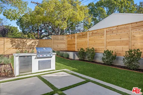 a view of a backyard with plants and brick wall