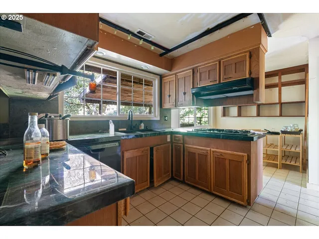 a kitchen with stainless steel appliances granite countertop a sink stove and cabinets