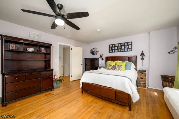 a bedroom with a bed a dresser and a book shelf