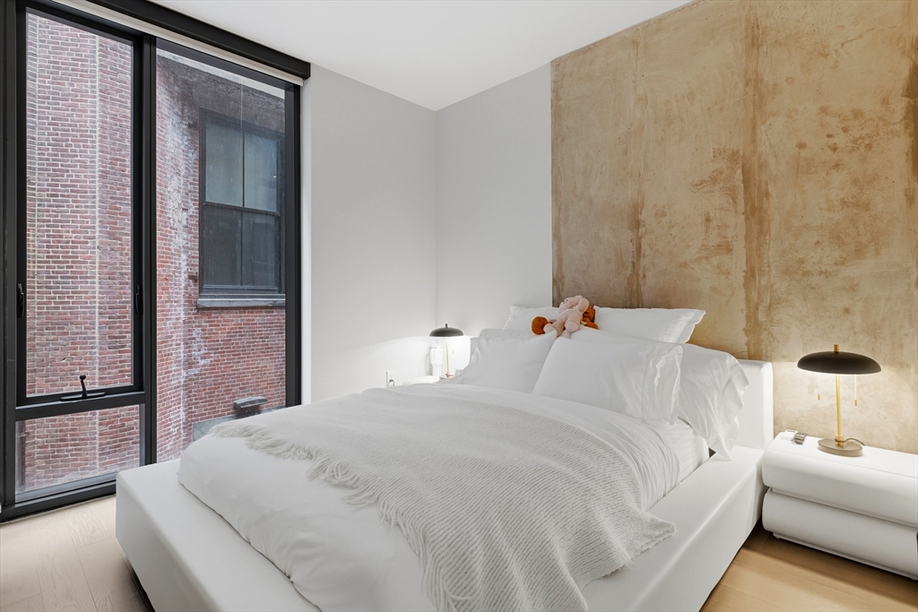 55 Lagrange Street, Unit 309 Boston, MA 02111 - Photo 11 of 20 a large white bed in a white room