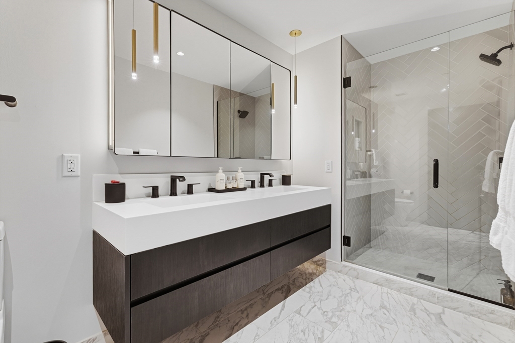 55 Lagrange Street, Unit 309 Boston, MA 02111 - Photo 12 of 20 a bathroom with a sink a toilet a mirror and shower