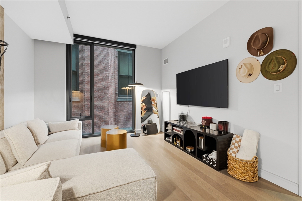 55 Lagrange Street, Unit 309 Boston, MA 02111 - Photo 2 of 20 a living room with furniture and a flat screen tv