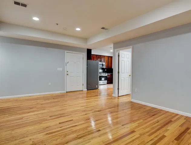 a view of an empty room with wooden floor