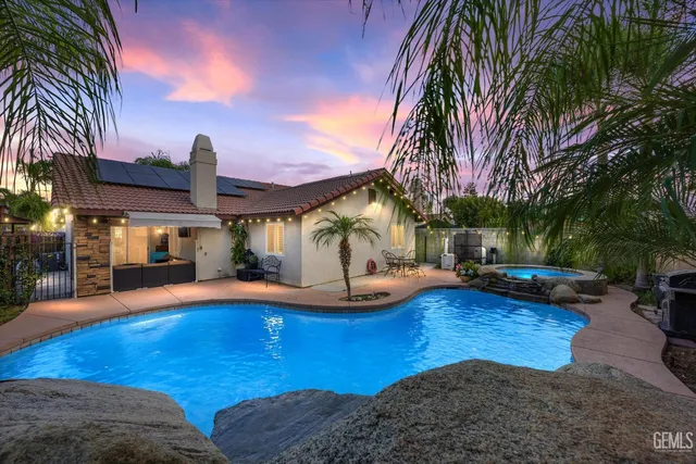 a view of a house with swimming pool and sitting area