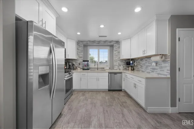 a bedroom with a bed a flat screen tv and a chandelier