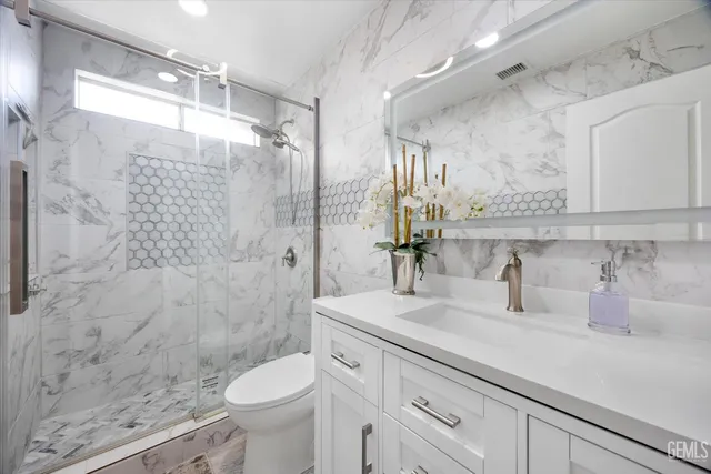 a backyard of a house with table and chairs potted plants and large tree