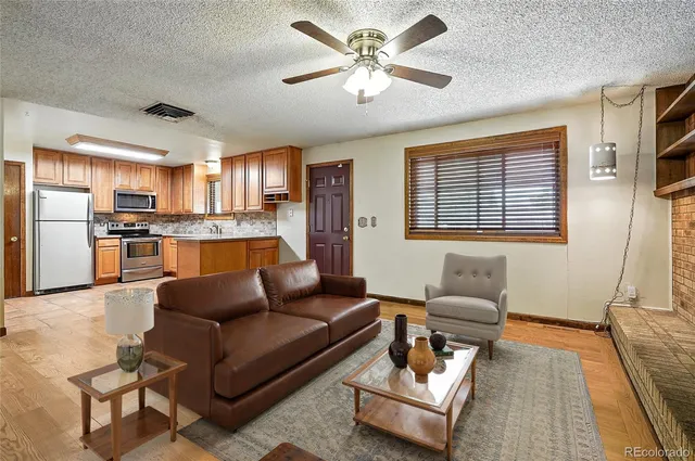 a living room with furniture and kitchen view