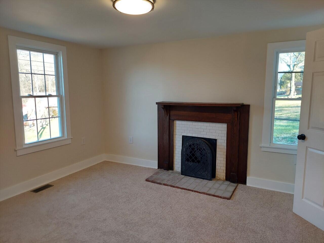2812 Webster Road Blue Ridge, VA 24064 - Photo 16 of 38 an empty room with windows and fireplace