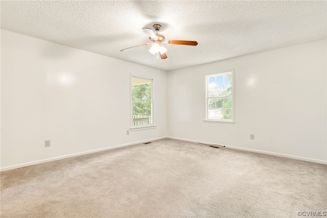 5158 Boydton Plank Road Brodnax, VA 23920 - Photo 14 of 43 an empty room with windows and chandelier fan
