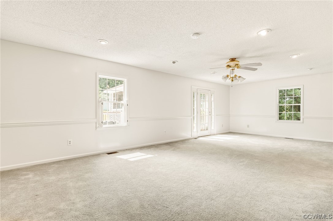 5158 Boydton Plank Road Brodnax, VA 23920 - Photo 17 of 43 an empty room with windows and chandelier fan