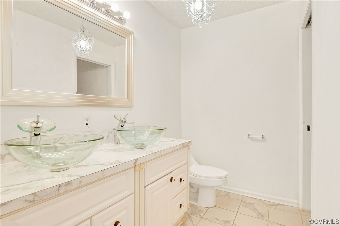 5158 Boydton Plank Road Brodnax, VA 23920 - Photo 20 of 43 a bathroom with a granite countertop sink a toilet and a mirror