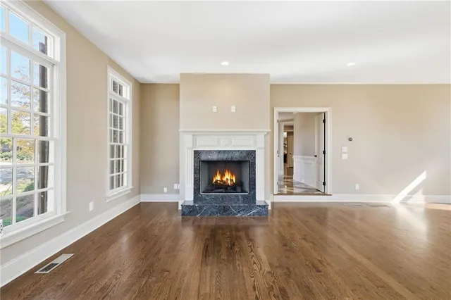 a kitchen with kitchen island granite countertop wooden floors stainless steel appliances a sink and a window