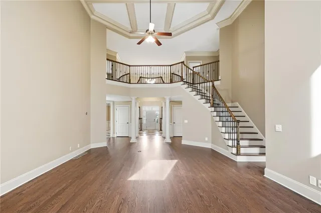 a view of an empty room with chandelier fan