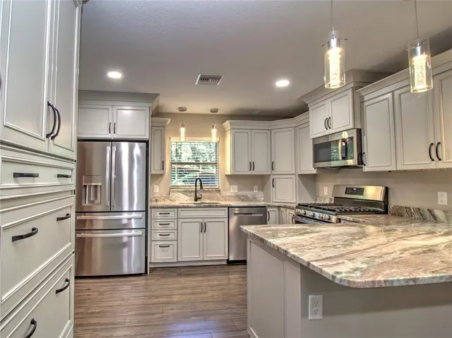 a kitchen with stainless steel appliances granite countertop a refrigerator stove and oven