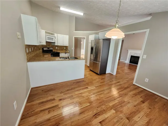 a kitchen with stainless steel appliances a refrigerator sink and microwave