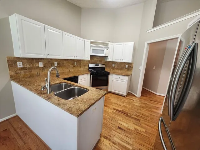 a kitchen with stainless steel appliances granite countertop a refrigerator and a sink