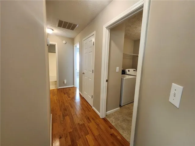 a view of a hallway with wooden floor