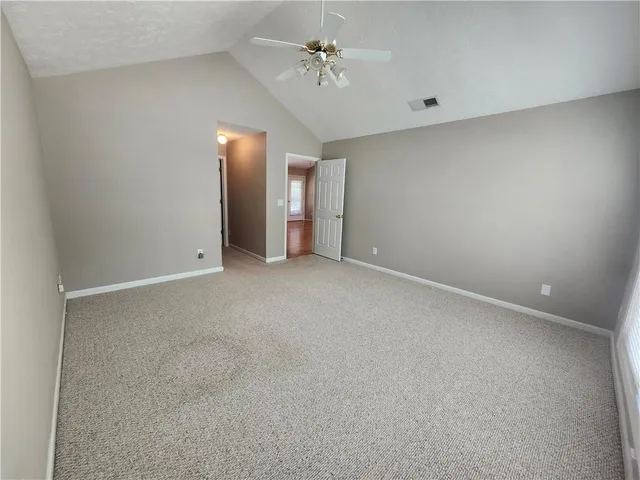 an empty room with a ceiling fan and a window