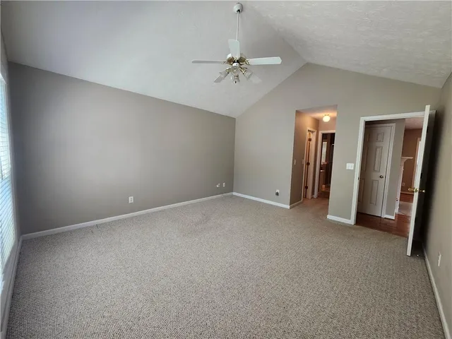 an empty room with closet and a chandelier fan