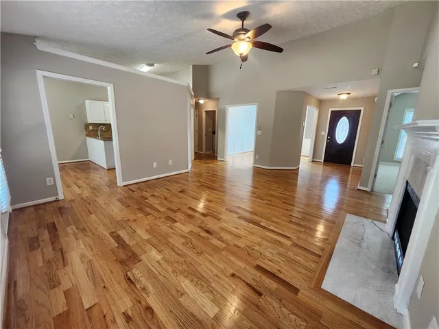 a view of a livingroom with wooden floor and a ceiling fan