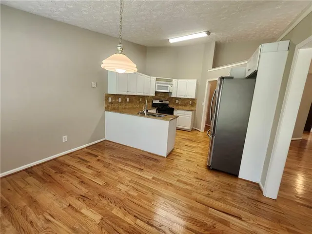a kitchen with granite countertop a refrigerator and a stove