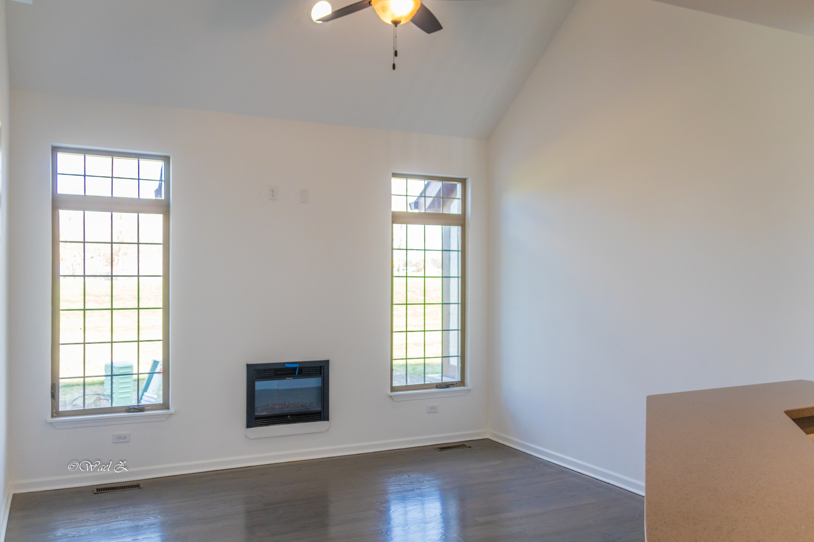 12728 Wild Rye Court, Unit B Plainfield, IL 60585 - Photo 2 of 21 an empty room with wooden floor chandelier fan and windows