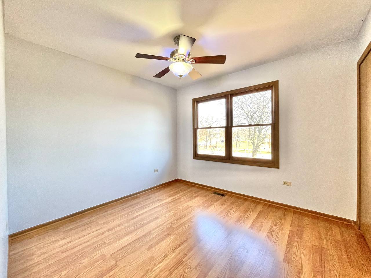 1689 Apple Valley Road Bolingbrook, IL 60490 - Photo 13 of 28 an empty room with wooden floor fan and windows