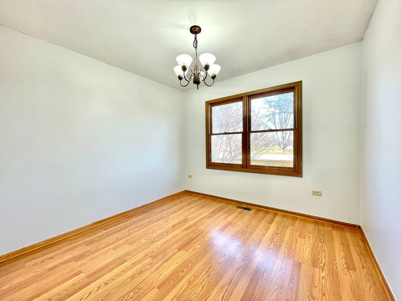1689 Apple Valley Road Bolingbrook, IL 60490 - Photo 14 of 28 a view of wooden floor in an empty room with a window