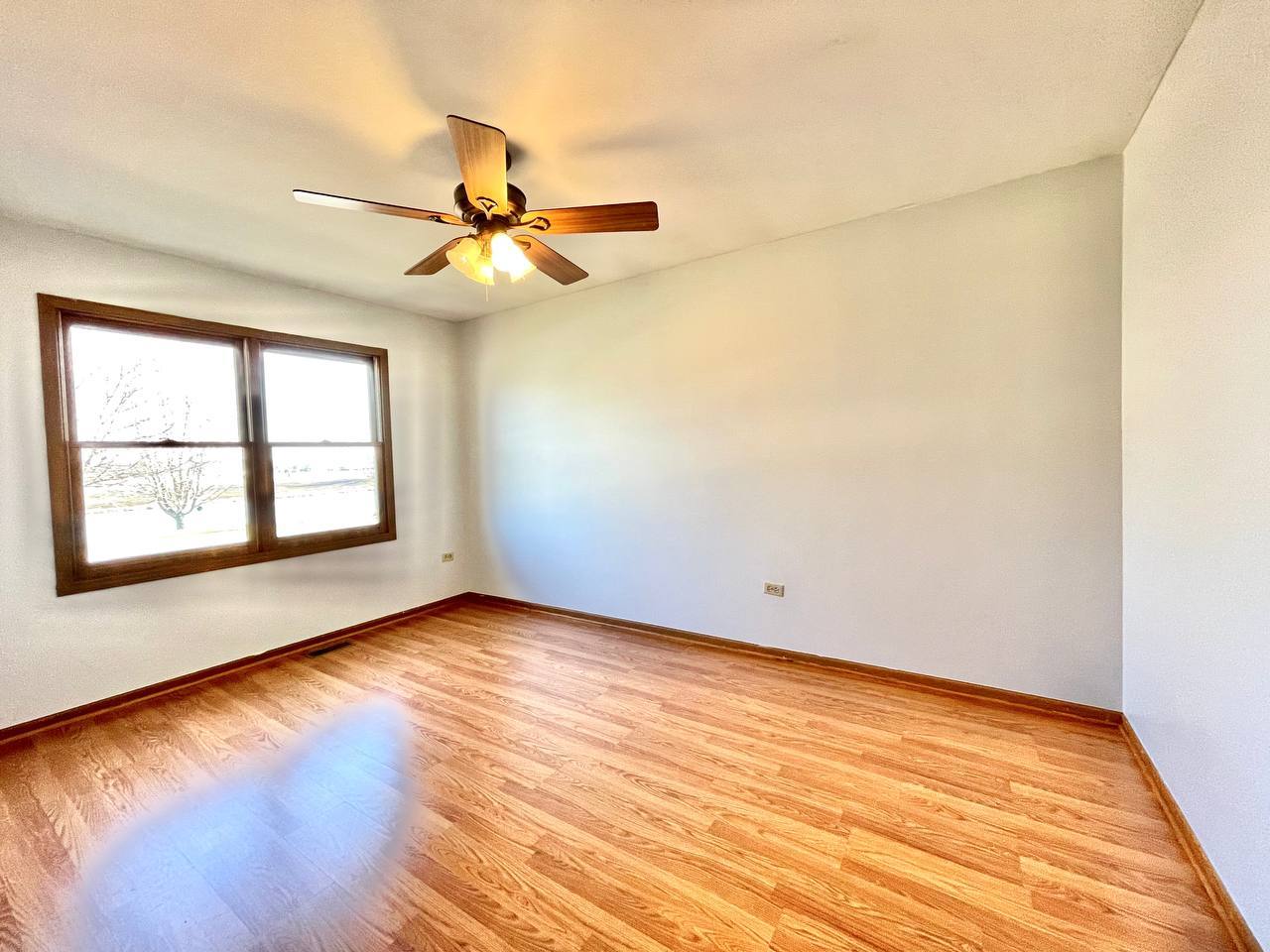 1689 Apple Valley Road Bolingbrook, IL 60490 - Photo 15 of 28 an empty room with wooden floor fan and windows