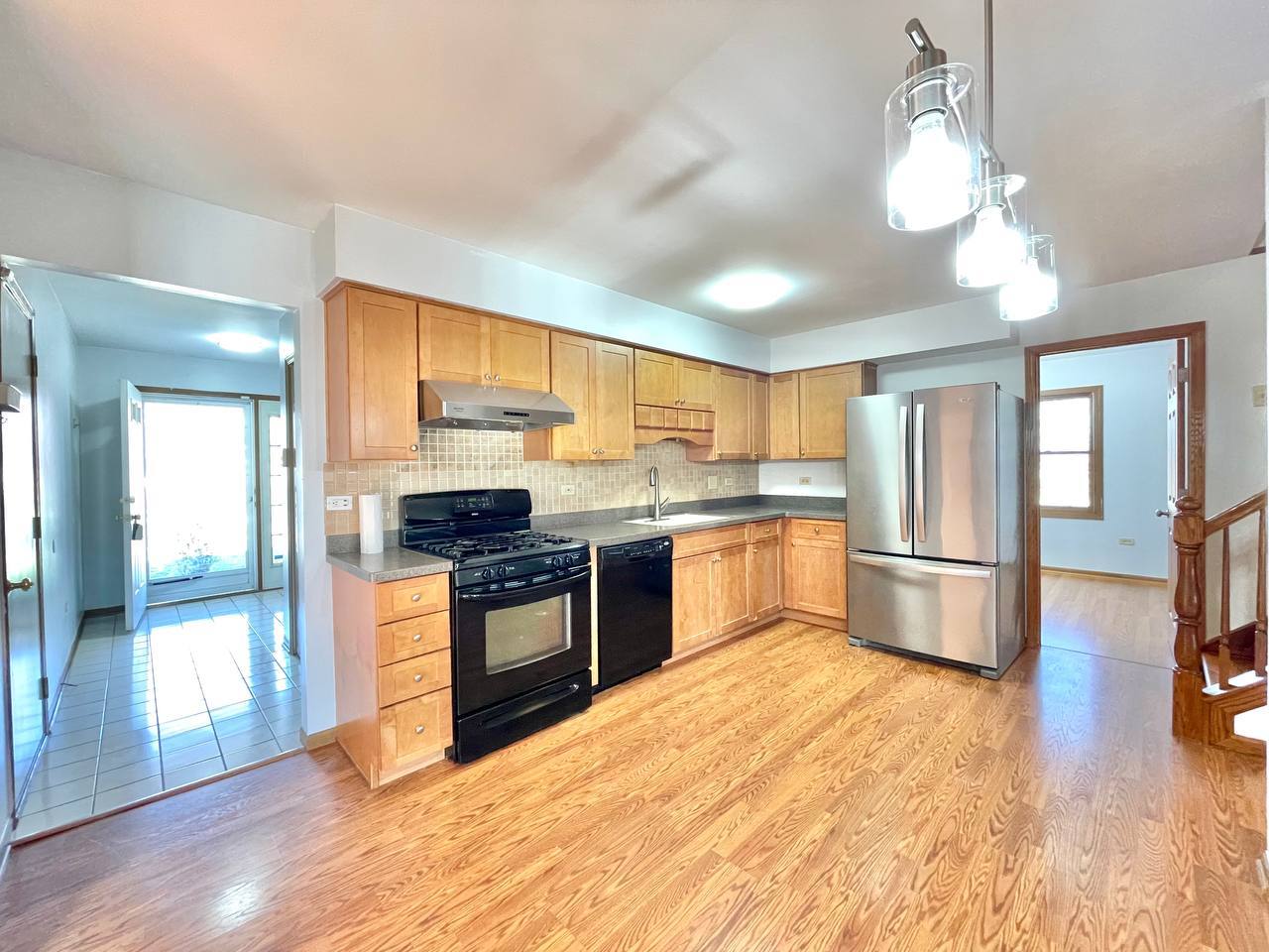 1689 Apple Valley Road Bolingbrook, IL 60490 - Photo 5 of 28 a kitchen with stainless steel appliances granite countertop a refrigerator a sink dishwasher a stove with wooden cabinets and floor