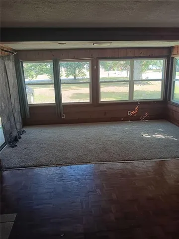a view of an empty room with a fireplace and a window