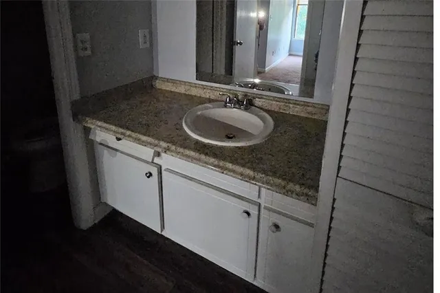 a bathroom with a granite countertop sink and a mirror