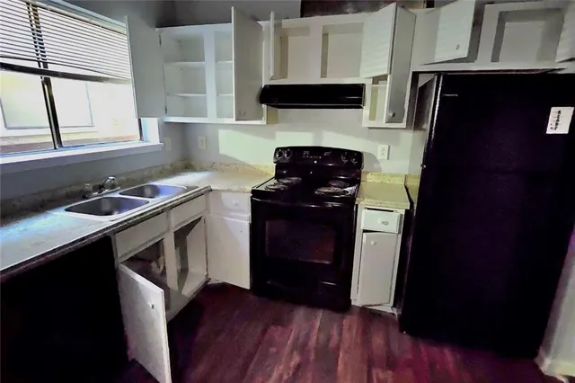 a kitchen with a sink a stove and cabinets