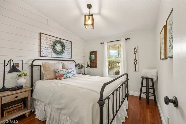 a bedroom with bed and wooden floor