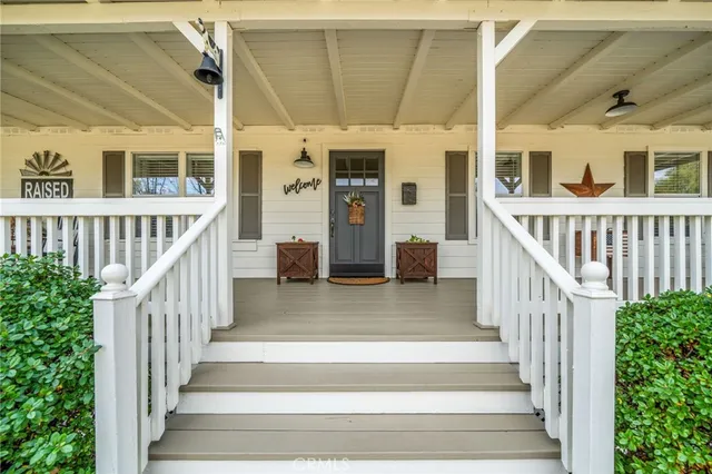 a roof deck with table and chairs and potted plants