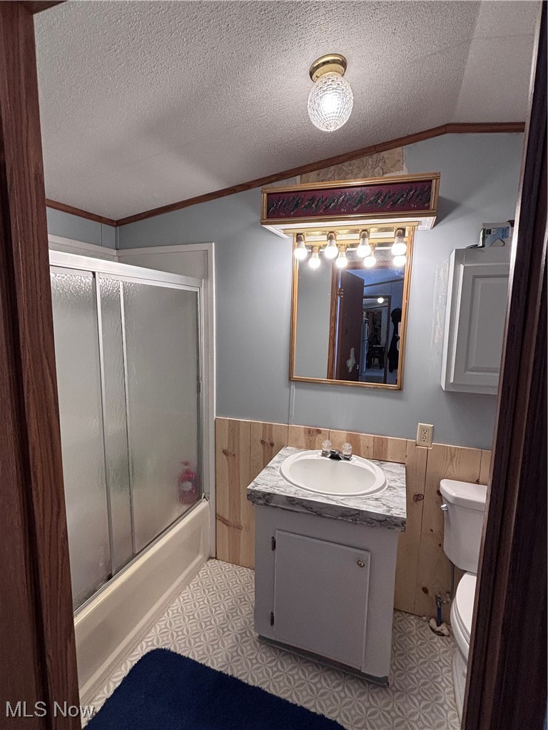 29311 Rabbit Ridge Road Howard, OH 43028 - Photo 16 of 39 Full bathroom with vanity, light flooring, shower / bath combination with glass door, wainscoting, and crown molding