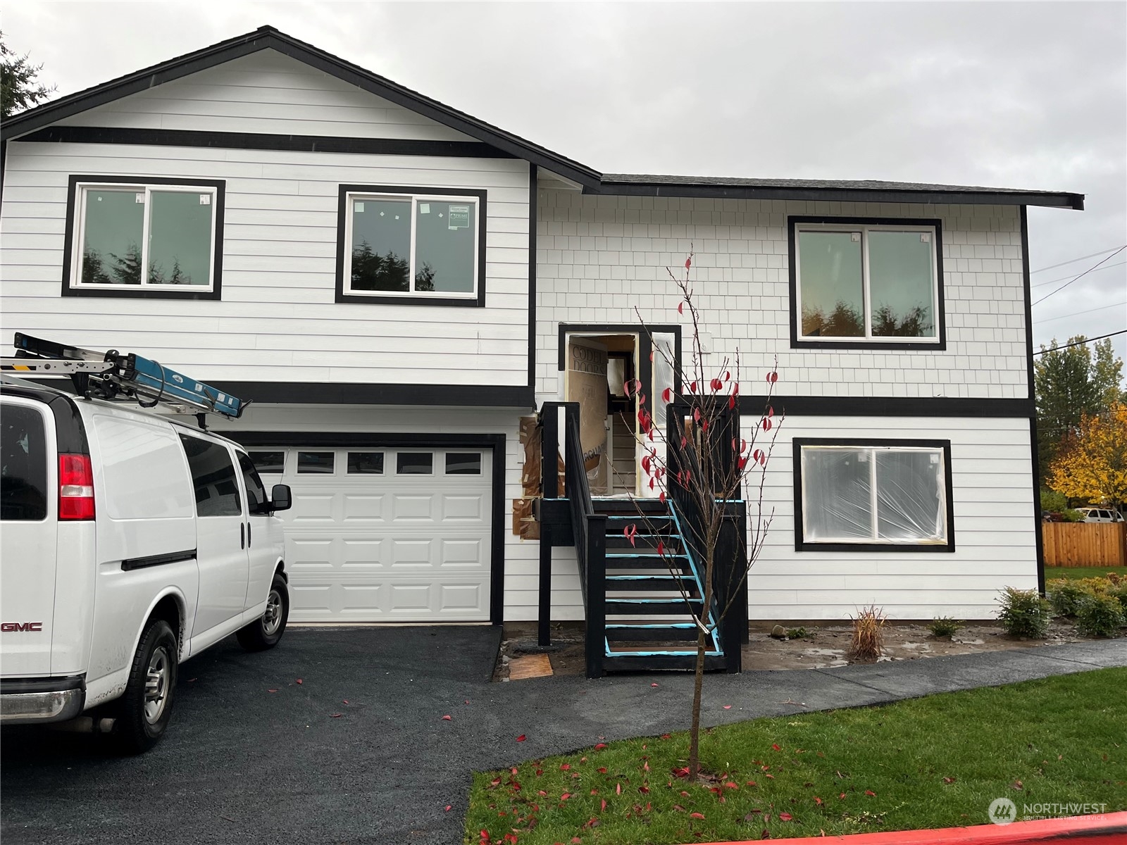 a view of a white house with a sink and a yard