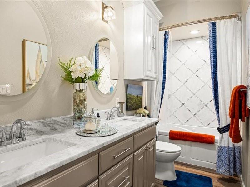 3510 Fountain Way Granbury, TX 76049 - Photo 12 of 27 Full bathroom featuring shower / tub combo, double vanity, a textured wall, and dark wood-style floors