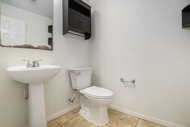 a bathroom with a sink toilet and mirror